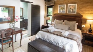 A well-lit bedroom with a large bed, bedside tables, a desk, and a chair. - Lake Villa Room 15 (Swartberg)