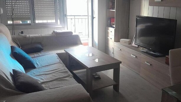 A living room with a sofa, a coffee table, a TV, and a cabinet. - Apartment in fair area (Albacete)