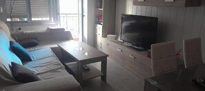 A living room with a sofa, a coffee table, a TV, and a cabinet. - Apartment in fair area (Albacete)