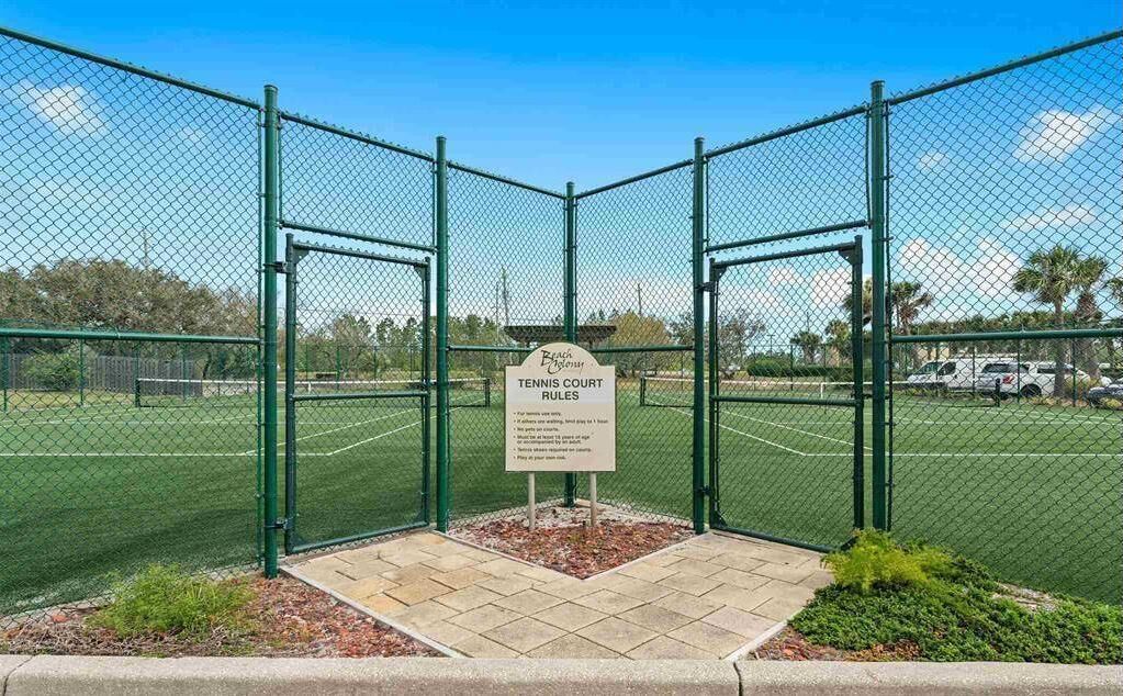 A tennis court with a sign detailing the rules.