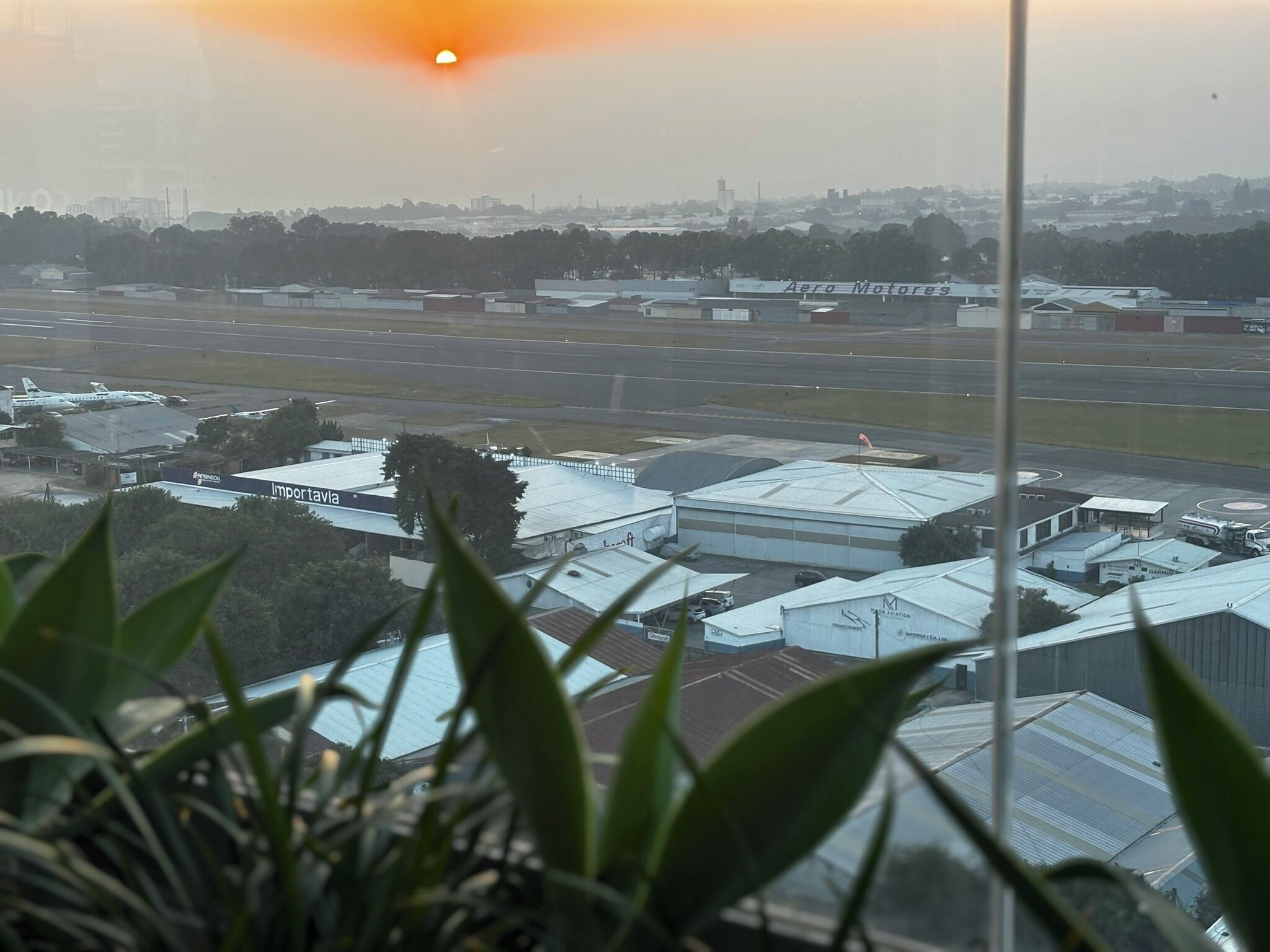 Un aéroport doté d’hangars et de bâtiments, dont l’un est identifié par l’inscription « Aero Motors ».