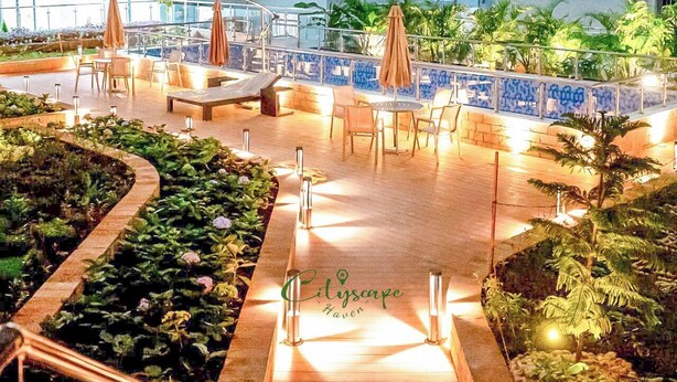 Un patio al aire libre con asientos, sombrillas y una fuente de agua.