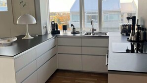 Eine moderne Küche mit einem großen Fenster, einer Spüle und einem Herd.