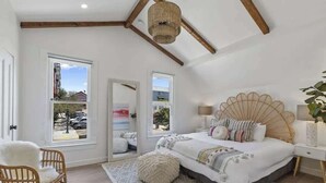 A bedroom with a large bed, two windows, a ceiling fan, and a view of the outside. - 4BR (Sleeps 10!)Heart of Little Italy: Walk to Dining & Fun! (San Diego)