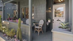 A house with a porch, a chair, and potted plants. - 4BR (Sleeps 10!)Heart of Little Italy: Walk to Dining & Fun! (San Diego)