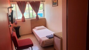 A small, neatly arranged room with a single bed, a desk, a chair, and a TV. - Tarrafal Residence (Tarrafal)