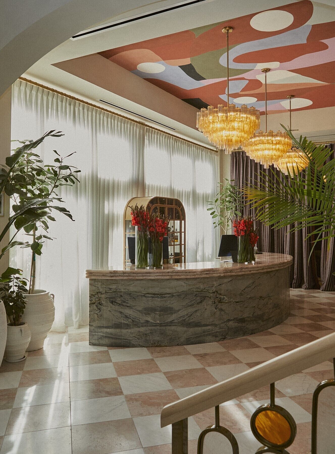 A reception area with a marble counter, potted plants, and a checkered floor.