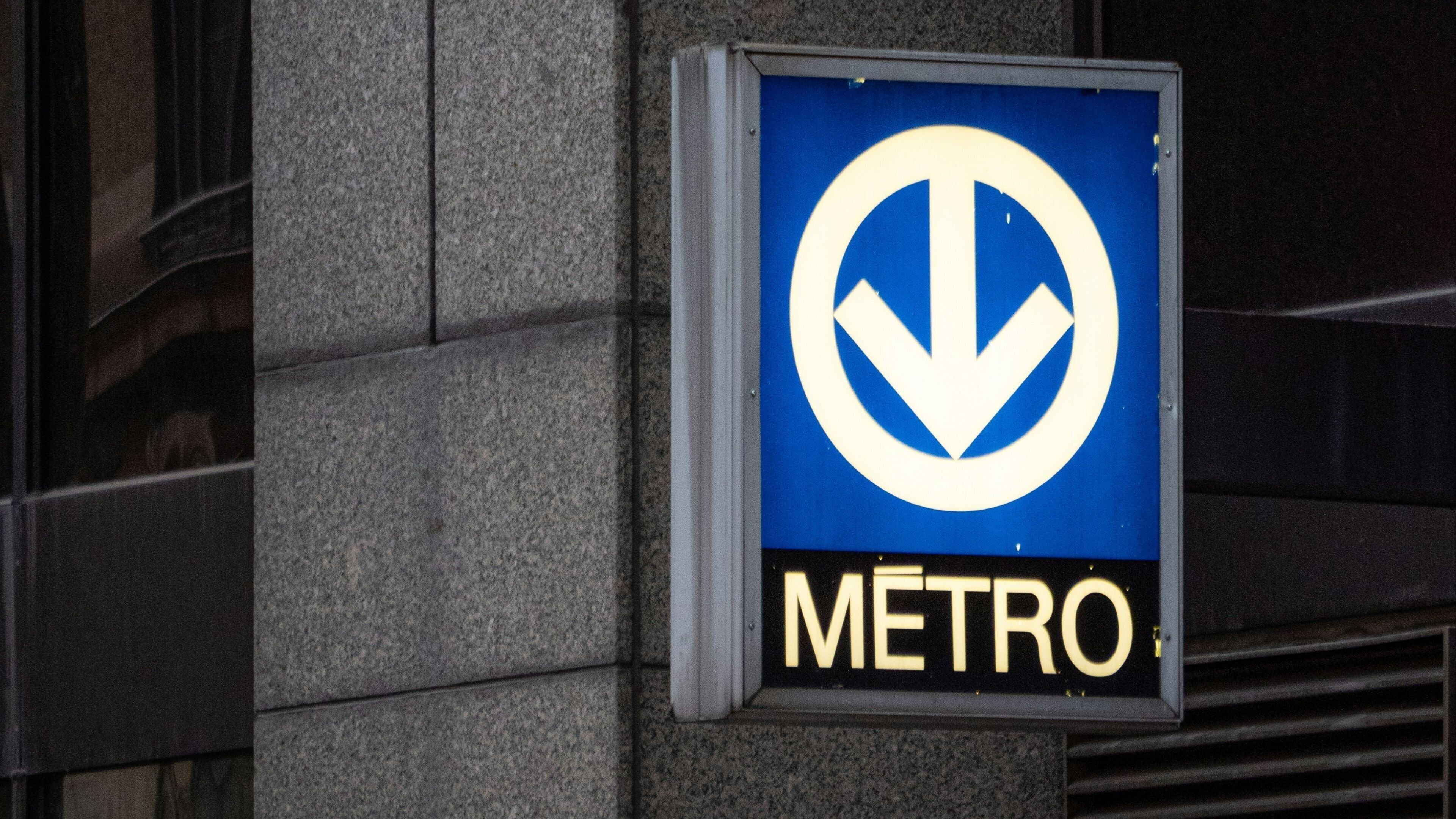 A blue sign with a white arrow pointing downwards and the word "METRO" in gold letters.