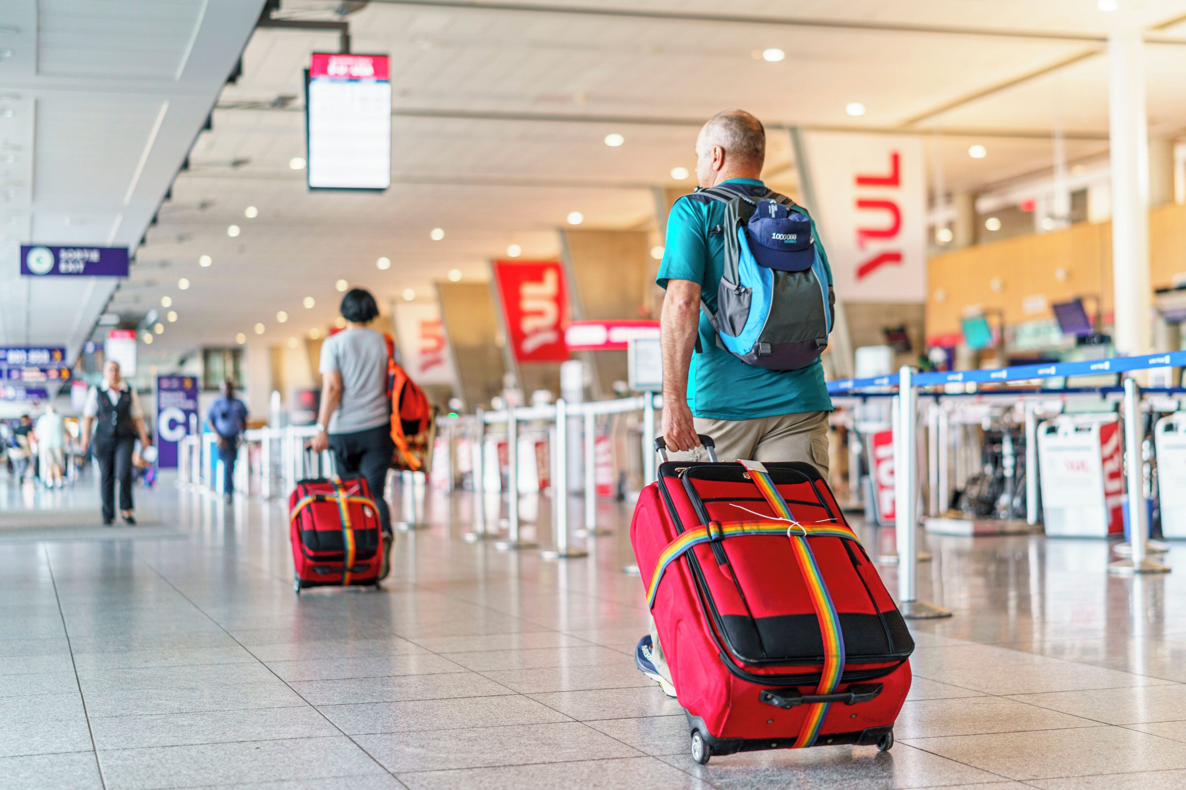 Een luchthaventerminal met incheckbalies en reizigers met bagage.