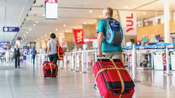 Een luchthaventerminal met incheckbalies en reizigers met bagage.