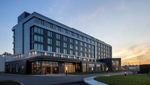 A modern hotel with a flat facade, large windows, and a well-lit entrance. - Holiday Inn Express Montreal Airport - St-Laurent by IHG (Montreal)