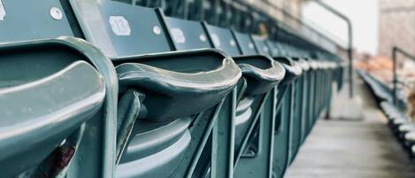 Rows of green stadium seats with visible seat numbers and a concrete floor.