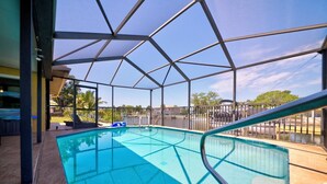 An indoor swimming pool with a clear view of the sky and surrounding area, enclosed by a metal frame structure. - 3-BR/2 Bath waterfront home with direct access to Gulf. Pool, kayaks and dock (Hernando Beach)