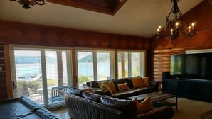 Una sala de estar acogedora con un sofá de cuero, un televisor de pantalla plana y una mesa de billar.