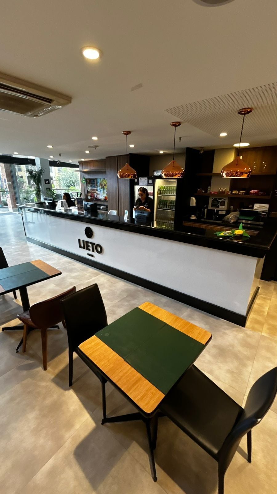 A restaurant interior with a counter, seating area, and visible kitchen equipment.