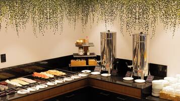 A buffet setup with various food items and beverage dispensers.