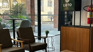 Eine Hotelhalle mit Sitzgelegenheiten, einer Rezeption und großen Fenstern.