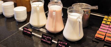 A dairy display with labeled containers of milk and yogurt, including natural and flavored varieties.
