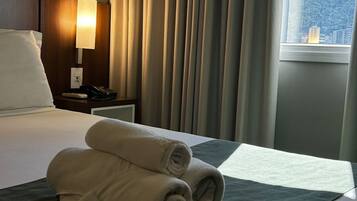 Suite Deluxe, vista a la ciudad | Escritorio, espacio para trabajar con laptop y cortinas blackout