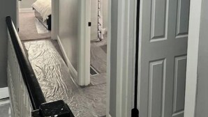 A hallway with a staircase leading to a bedroom. - Comfort Zone (Wilmington)