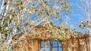 A treehouse with a wooden structure, a window, and a balcony. - Riad salix d'agafay (Marrakech)