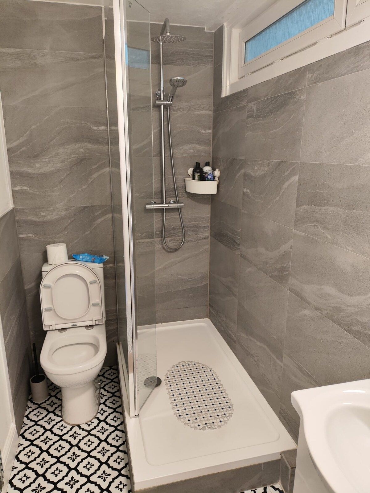 A bathroom with a shower, toilet, and bidet.