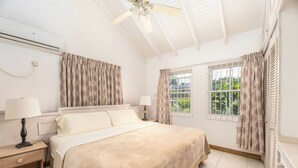 A bedroom with a bed, two bedside tables, a ceiling fan, and a window with curtains. - Vida Mejor--Poolside (Private Pool) (Holetown)