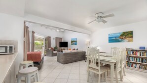 A spacious living area with a dining table, chairs, a sofa, and a bookshelf. - Vida Mejor--Waterfall (Private Pool) (Holetown)