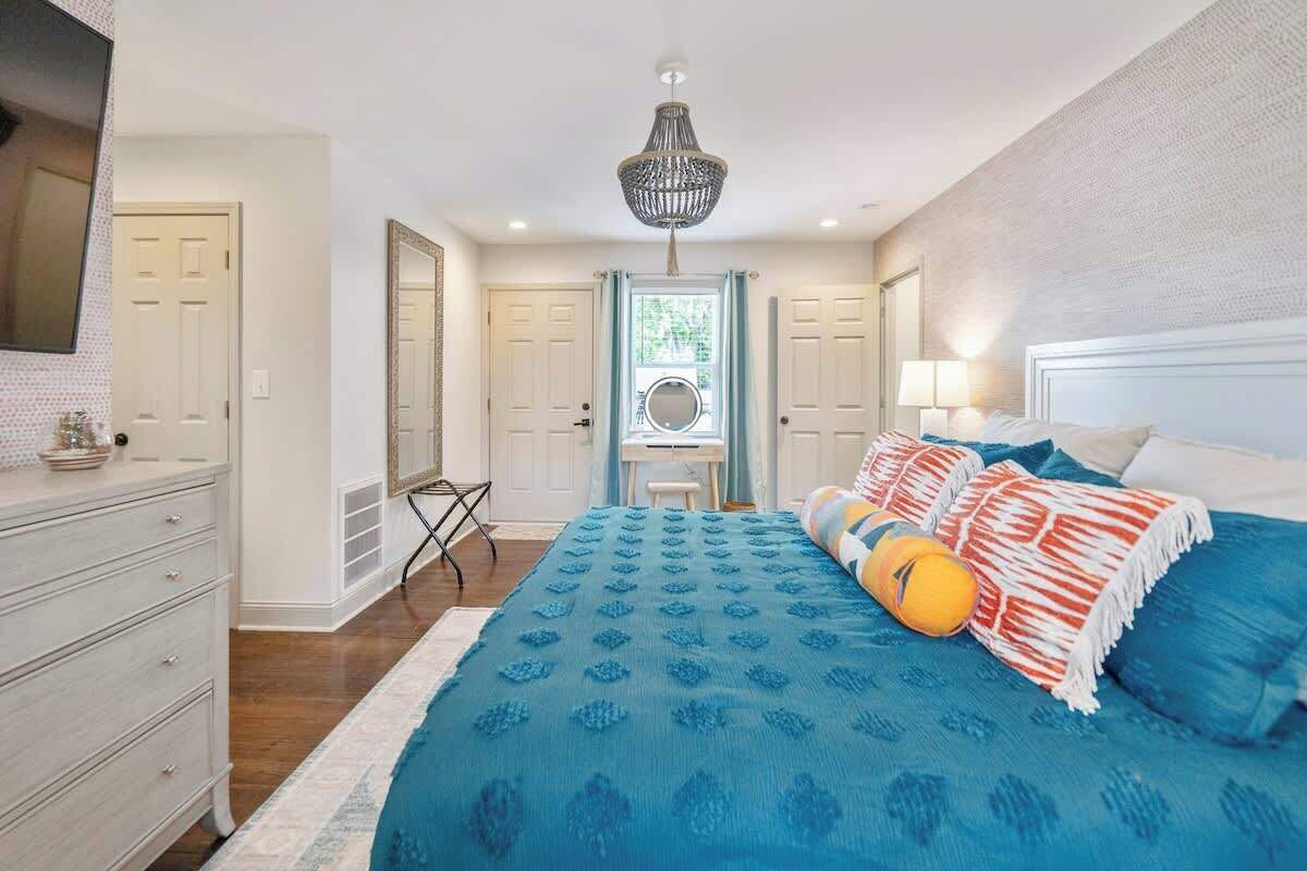 Un dormitorio con una cama grande, una araña y vistas al exterior.