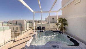 A hot tub on a balcony with a clear view of the surrounding buildings.