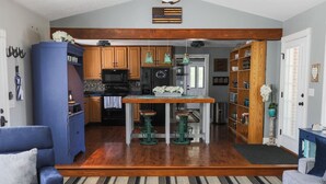 A kitchen with wooden cabinets, a central island, and hanging pendant lights.