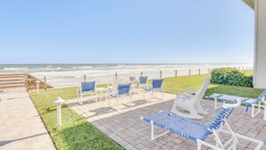 A beachside patio with lounge chairs and a view of the ocean. - Couples Retreat at Colony Beach Club (New Smyrna Beach)