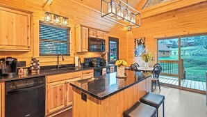 Cozinha moderna com armários de madeira, uma ilha grande e vista para o quintal.