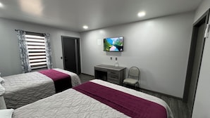 A hotel room with two beds, a desk, a chair, a TV, and a window with curtains. - REL-X INN (Ahumada)