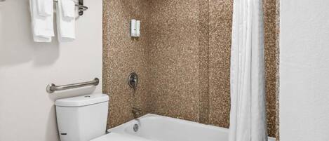 Ein modernes Badezimmer mit Toilette, Badewanne und Duschvorhang.