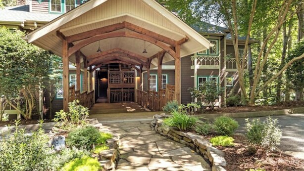 A covered entrance with a stone pathway leading to a wooden building. - The Camp - Luxe Blue Ridge Condo (Burnsville)