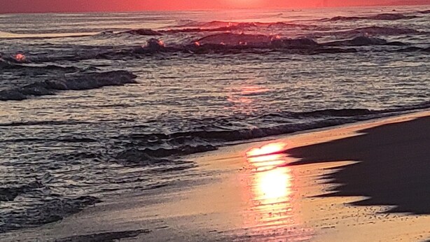 A sunset over the ocean with waves crashing onto the shore. - 3 Bedroom Townhouse, Access to 4 pools, hot tub, & a 5 minute walk to white sand (Panama City Beach)