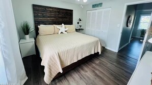 A bedroom with a bed, a ceiling fan, a nightstand, a potted plant, and a closet. - 3 Bedroom Townhouse, Access to 4 pools, hot tub, & a 5 minute walk to white sand (Panama City Beach)