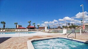 A swimming pool with a brick deck, surrounded by a fence and palm trees. - 3 Bedroom Townhouse, Access to 4 pools, hot tub, & a 5 minute walk to white sand (Panama City Beach)