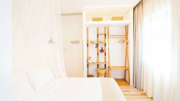A bedroom with a bed, a wooden ladder, shelves with baskets, and a hanging rack.