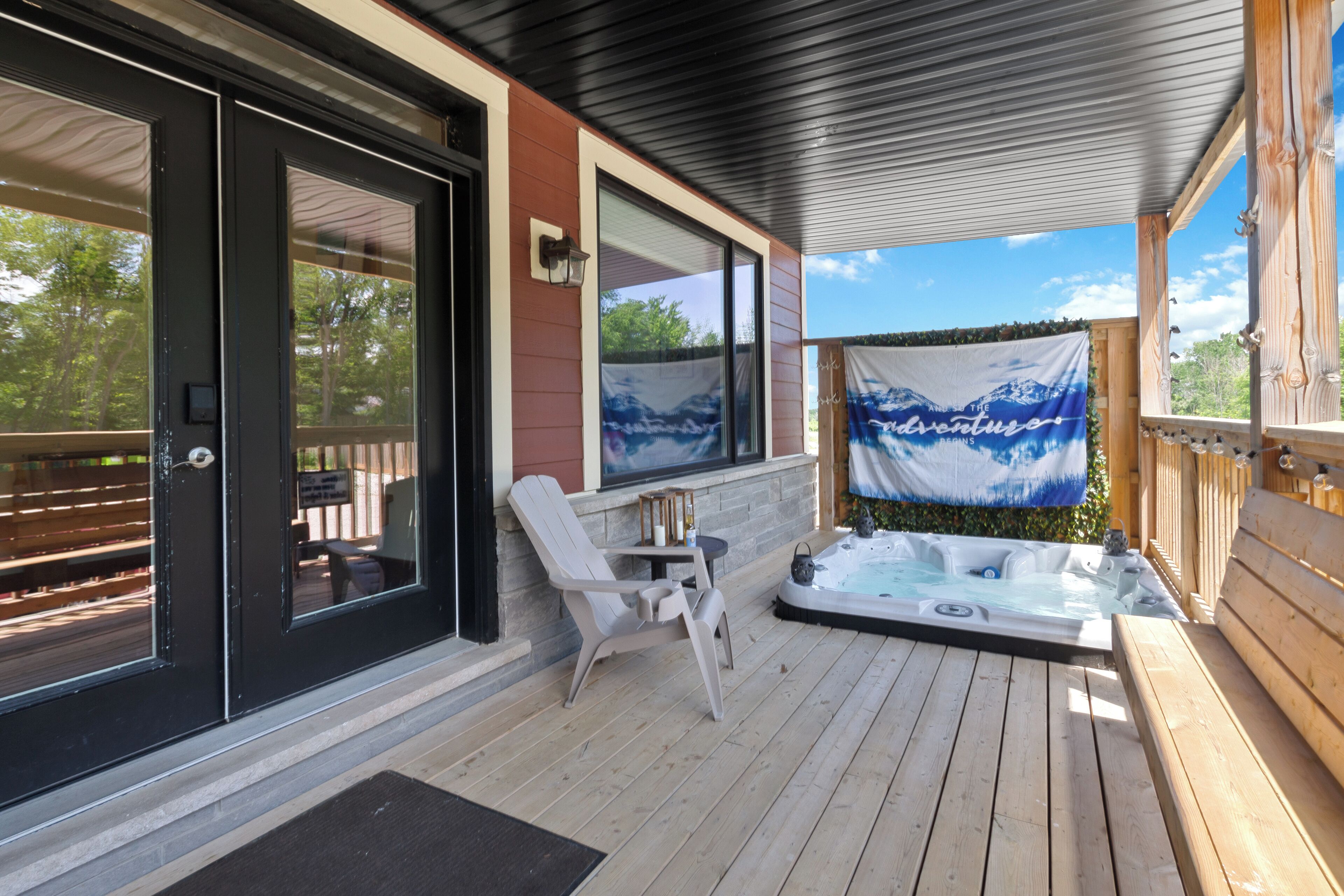 Una terraza de madera con un jacuzzi, una silla y una mesa.