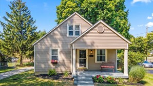 A single-story house with a front porch, a small attached garage, and a front yard with a pathway leading to the entrance. - Downtown Zen - Central Location in Centerville, OH (Centerville)