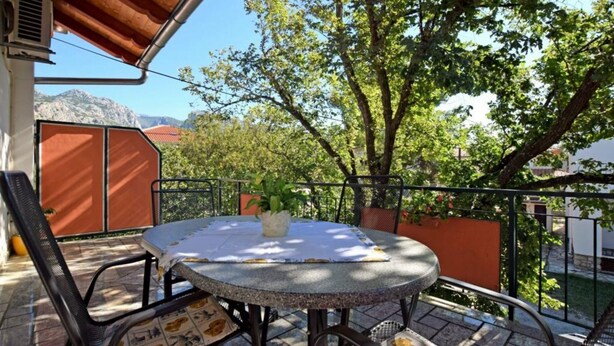 A round table with a white tablecloth and metal chairs on a balcony with a view of trees and mountains. - Apartments Adriana - One Bedroom Apartment A2+1 (Starigrad-Paklenica)