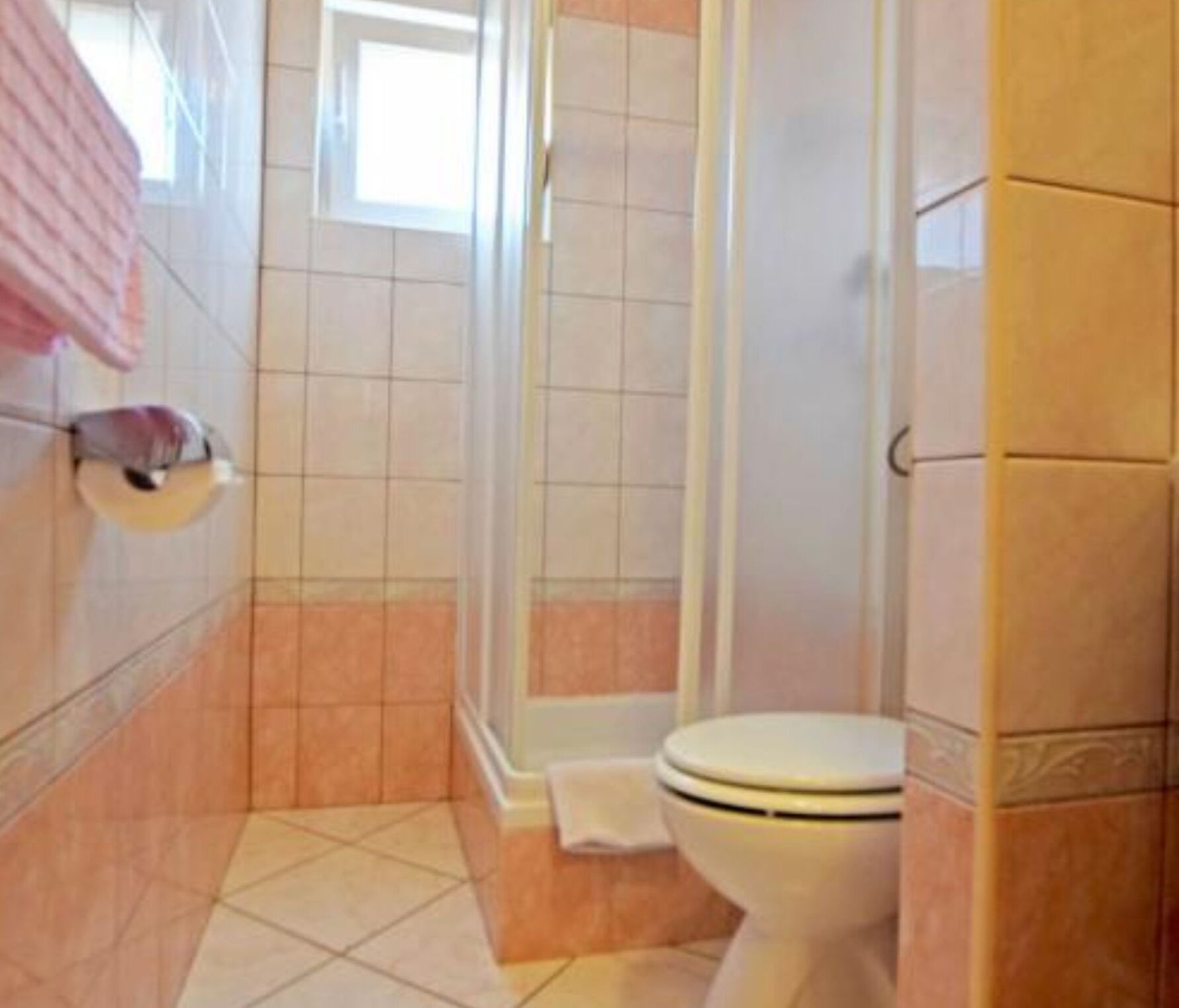 A bathroom with a toilet, a shower, and a sink.