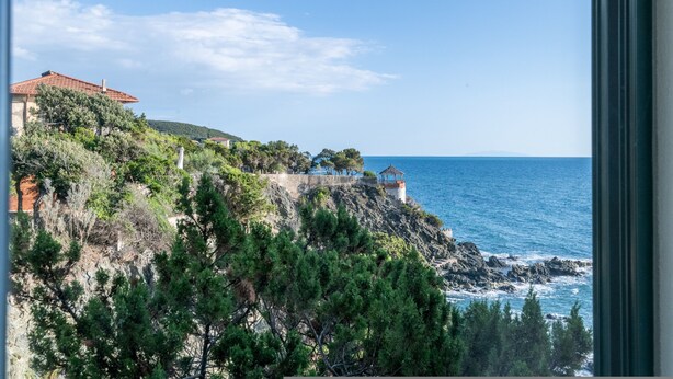 A coastal view with a building on a cliff, overlooking the sea. - Magic Seaside Apartment (Rosignano Marittimo)