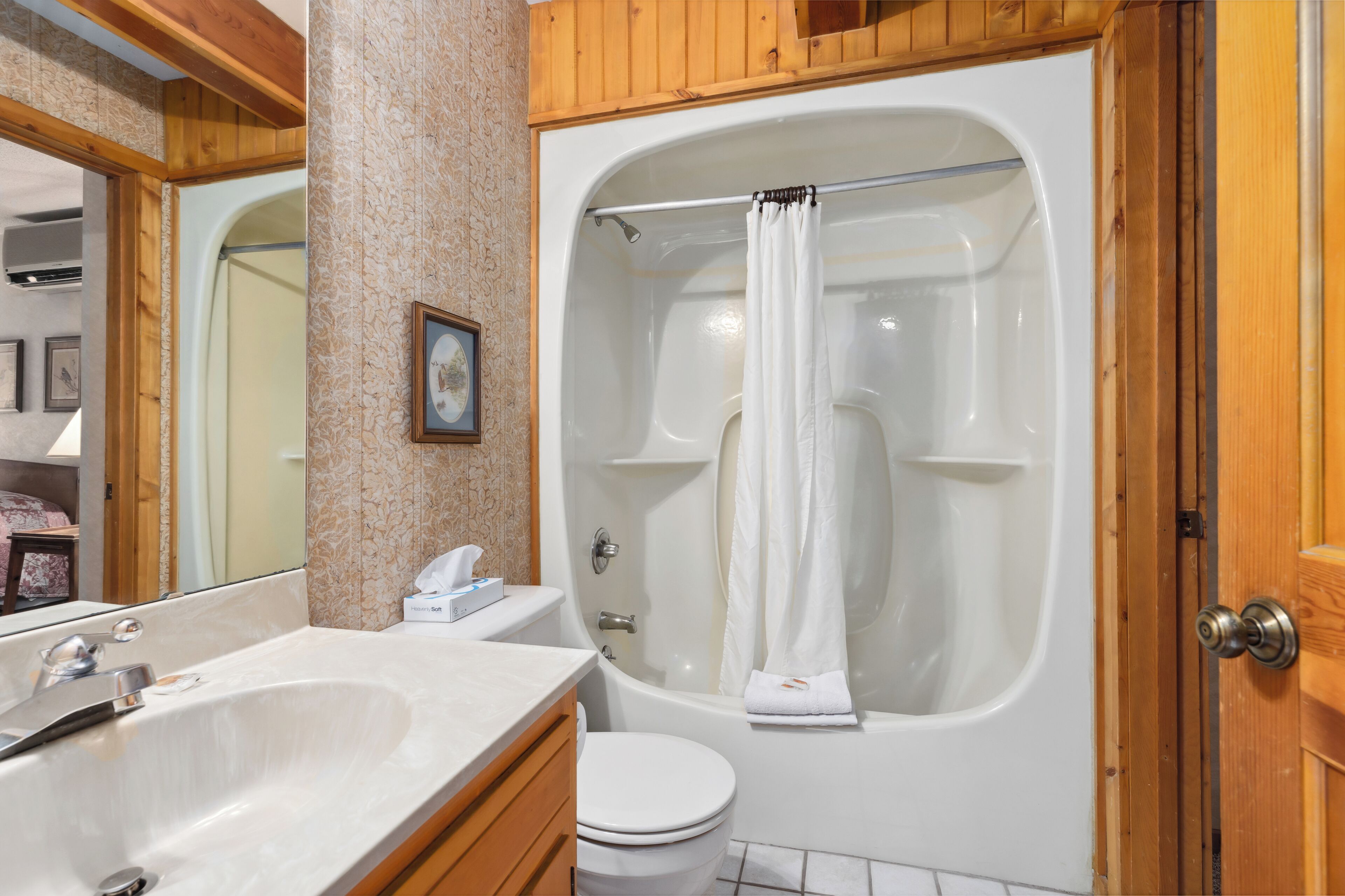 A bathroom with a bathtub, a toilet, and a sink.