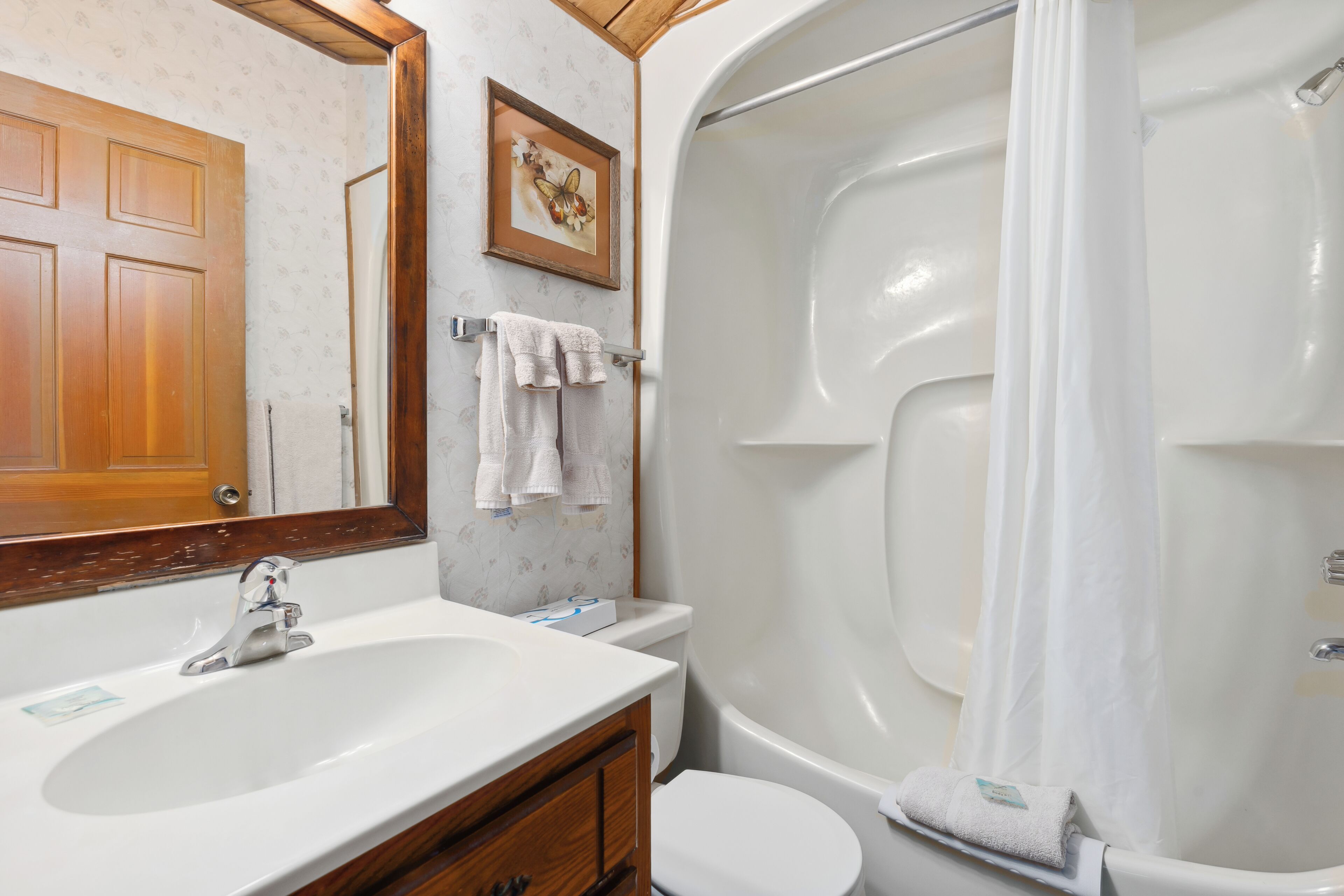 A bathroom with a sink, toilet, and bathtub.