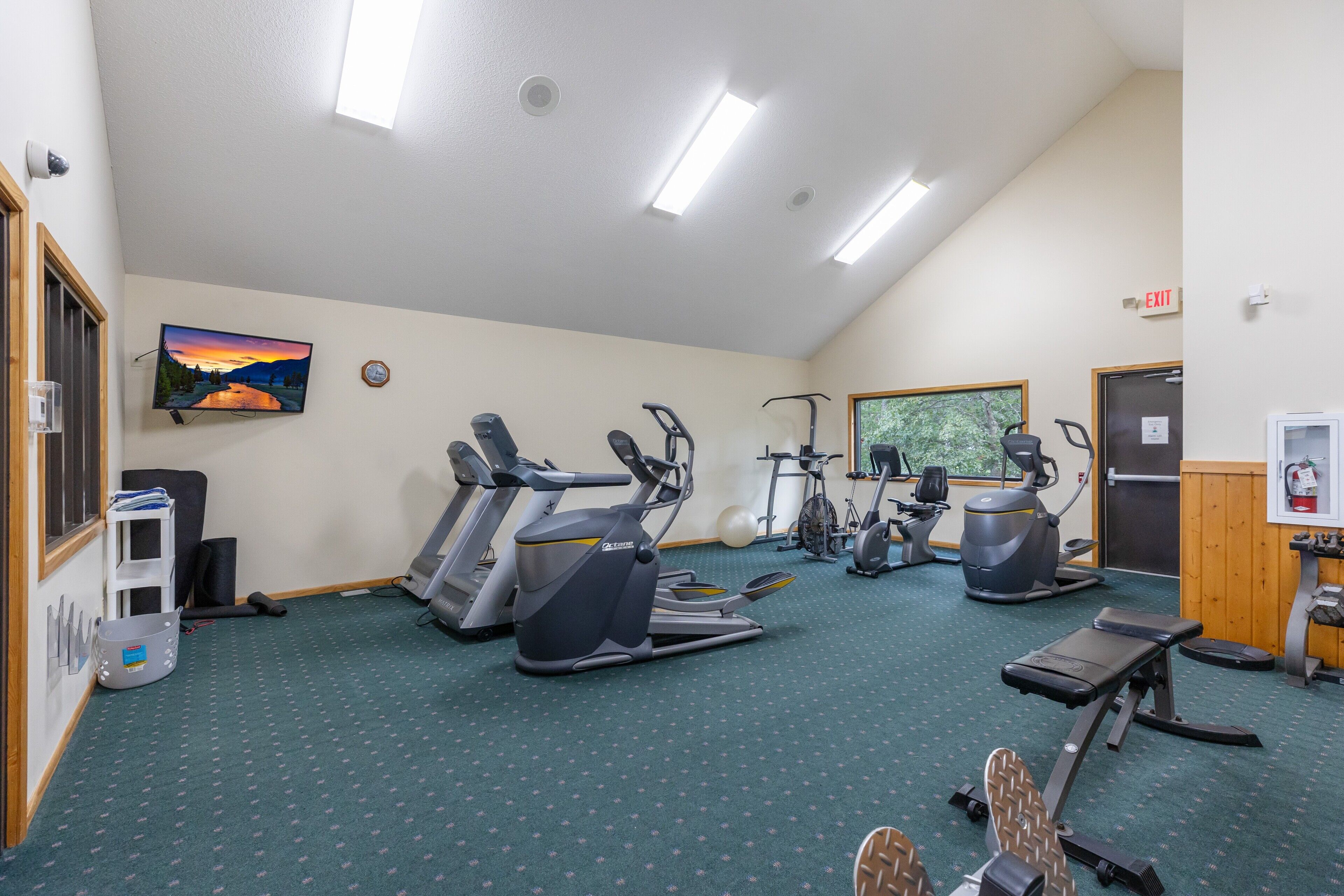 A gym with treadmills, elliptical machines, and a stationary bike.