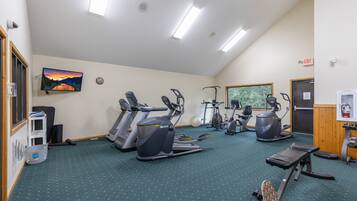 A gym with treadmills, elliptical machines, and a stationary bike.
