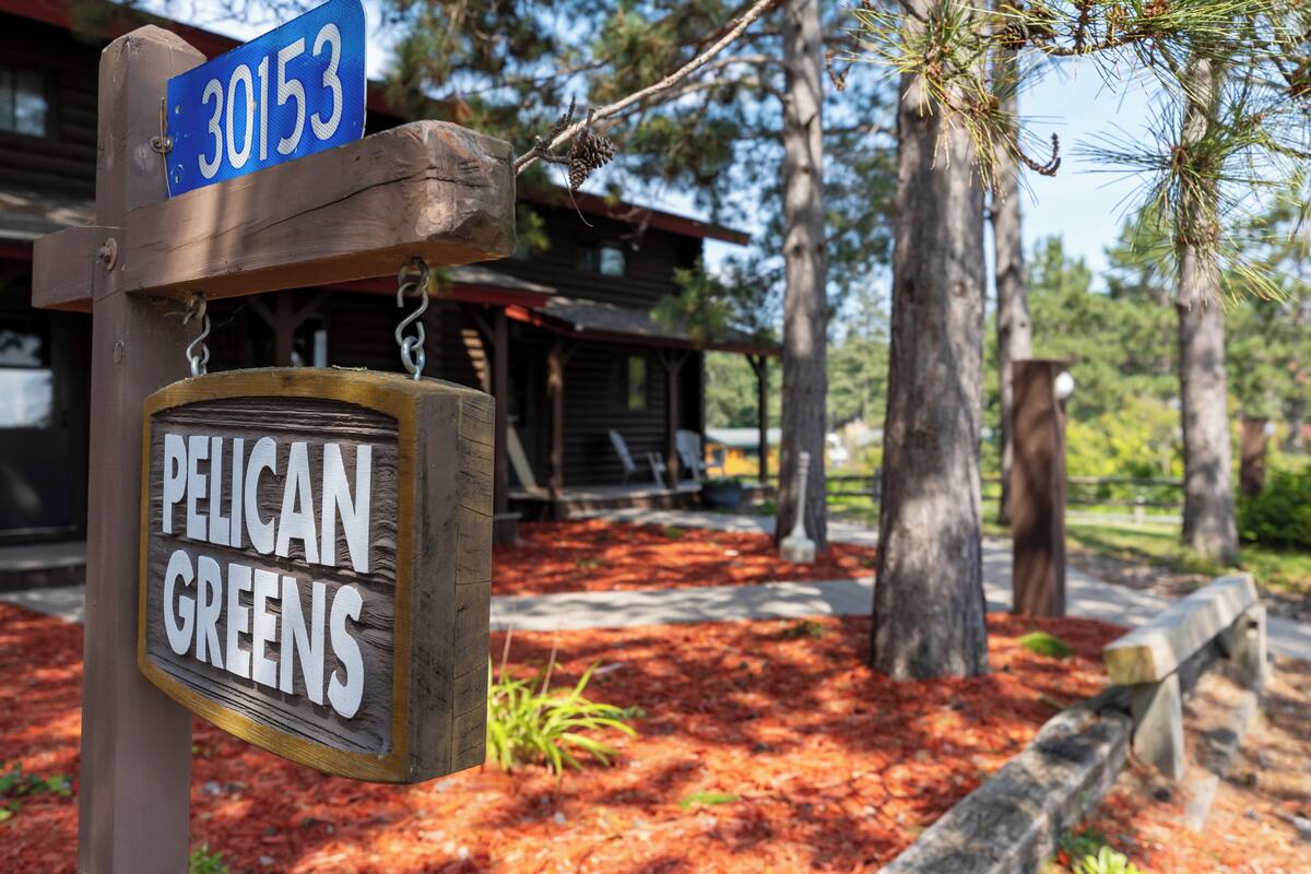 A wooden sign with 'Pelican Greens' and a number '30153'.